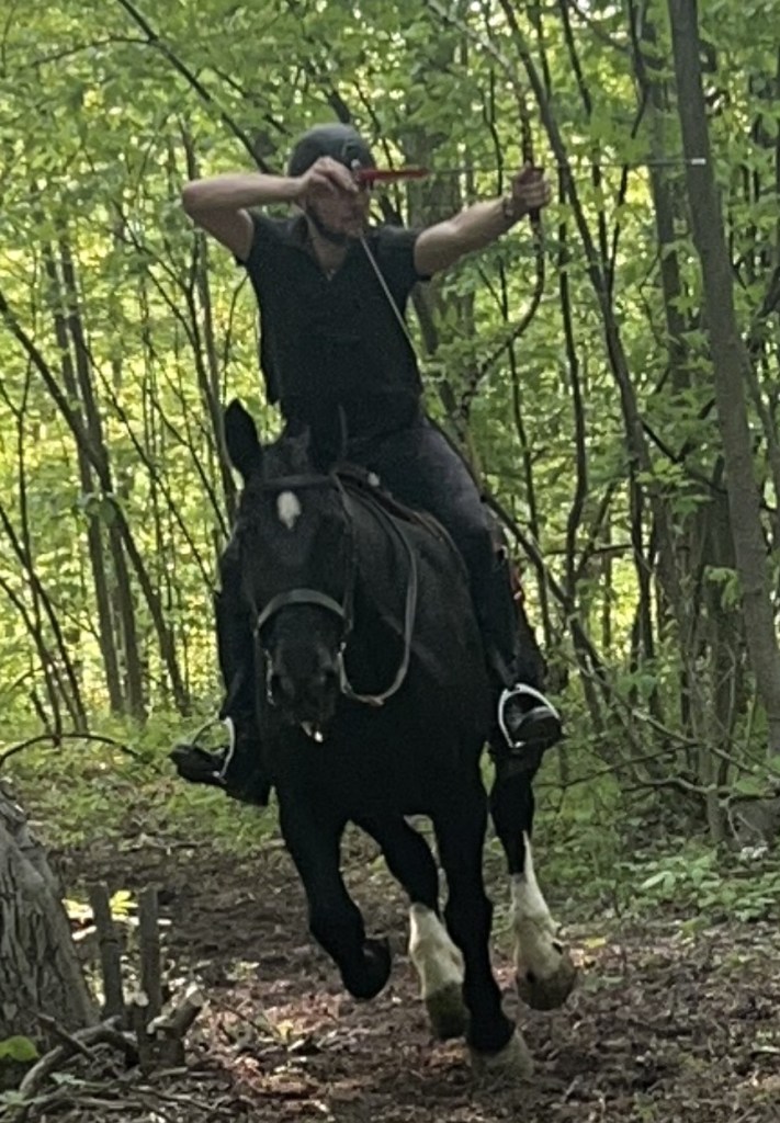 Horseback rider doing mounted archery in the forest