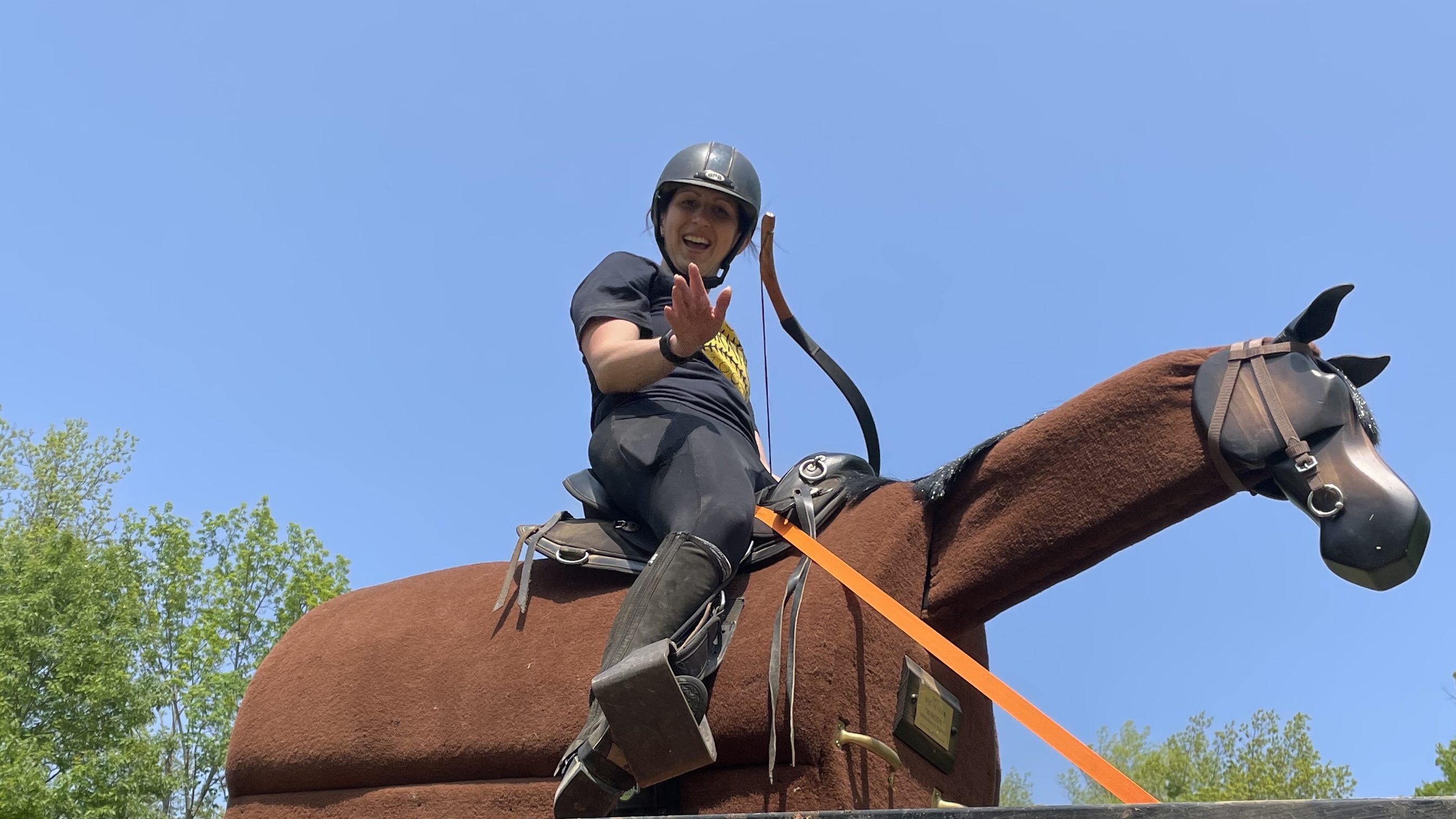 Friendly horseback rider on wooden horse practicing mounted archery