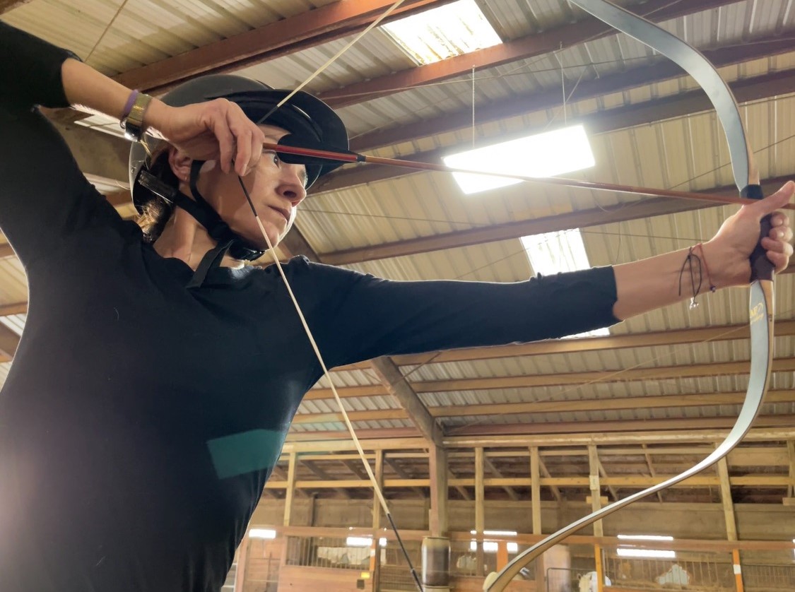 Mounted archer at full draw with thumb ring, prepared to shoot