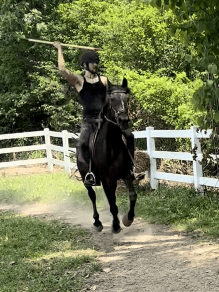 Man riding a horse throwing a lance