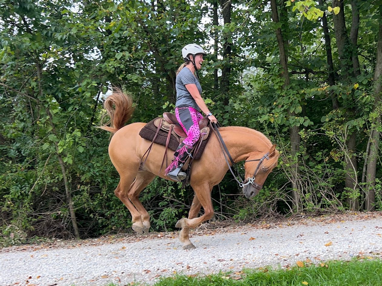 Smiling woman riding a bucking horse